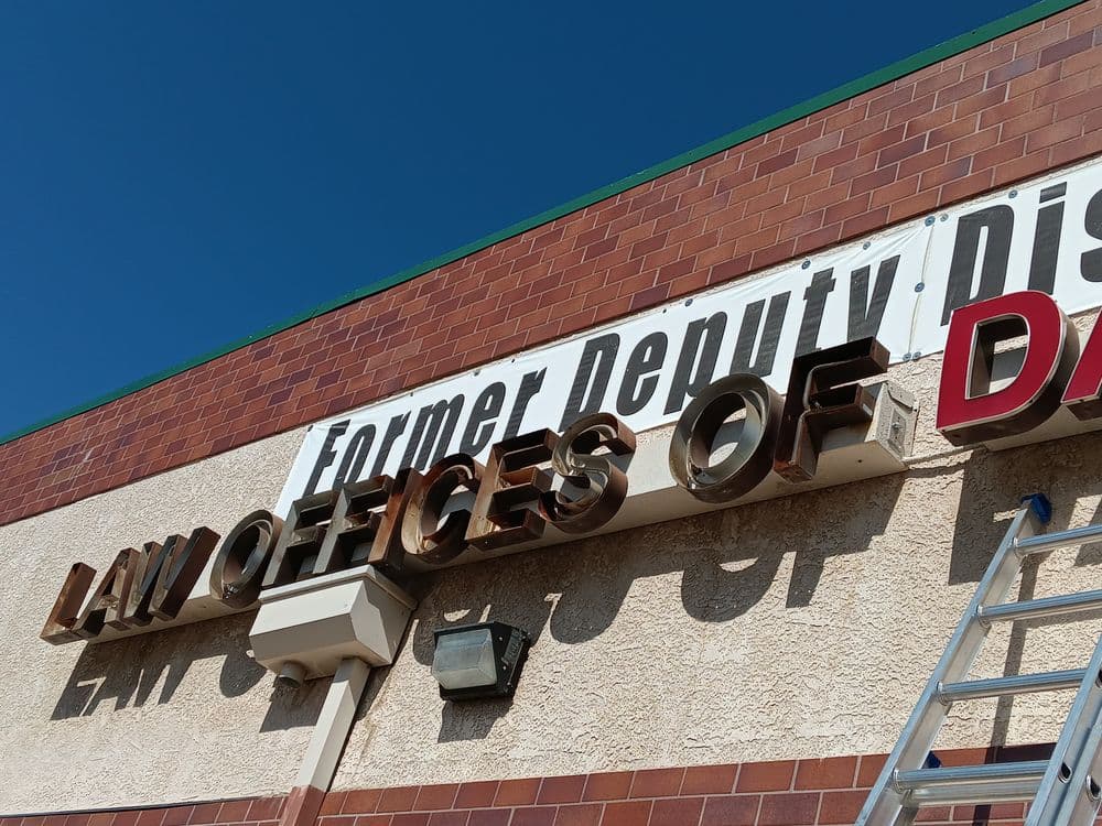 Signage of Law Offices of David with renovation work, under a blue sky.