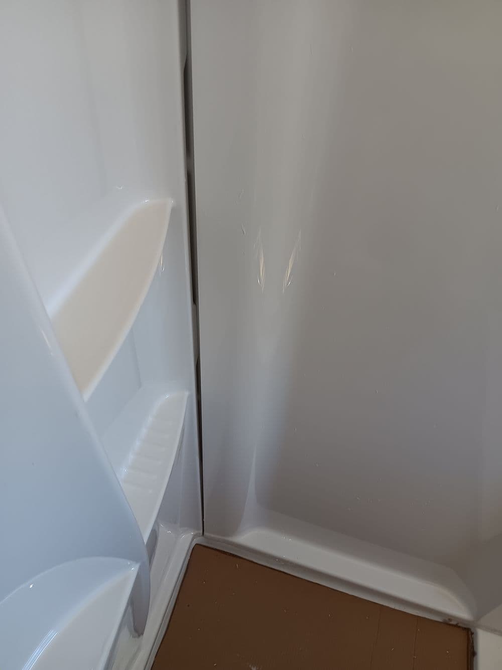 Clean white shower interior with built-in shelves and a smooth finish.