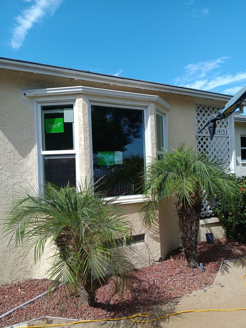 Newly installed bay window on a residential home surrounded by tropical plants.